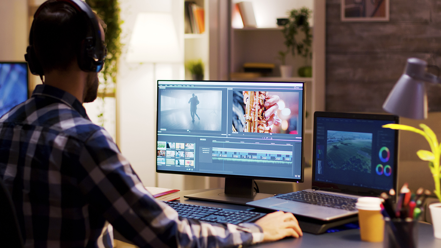 Man wearing headphones doing video production on desktop computer